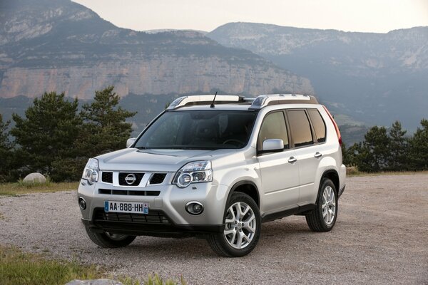 SUV nissan x-trail sur fond de montagnes