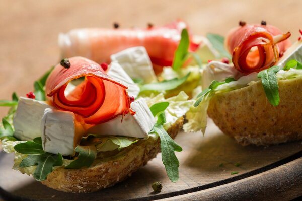 Aperitivo en forma de bote de pan con queso, jamón y verduras