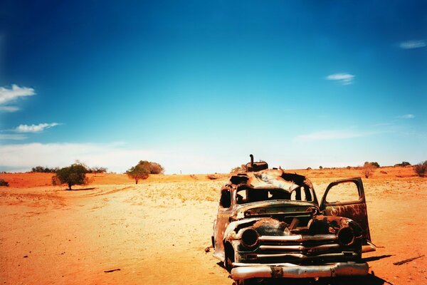 Coche viejo en medio del desierto contra el cielo