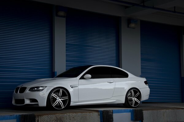 Una bella BMW bianca si riflette su uno sfondo scuro 