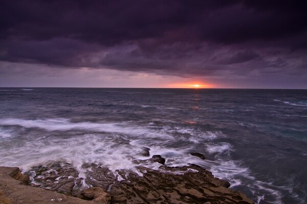 Hermosa puesta de sol junto al mar oscuro