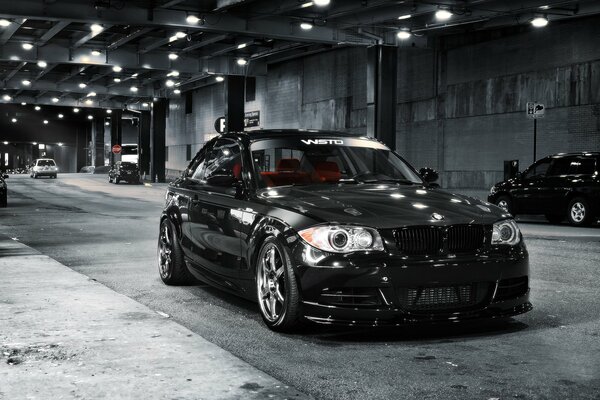 A shiny black car in the parking lot