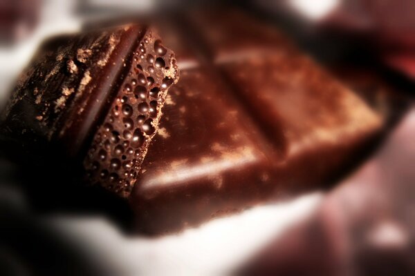 Pieces of airy porous chocolate. Blurred background