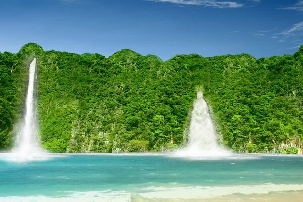 El paisaje con los colores jugosos de la cascada se hunde en el verde