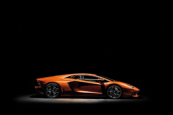 Orange lamborghini aventador on a black background