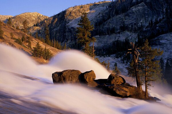Le contraste incroyable du paysage: le soleil avec le brouillard à gauche, la neige au pied des montagnes à droite