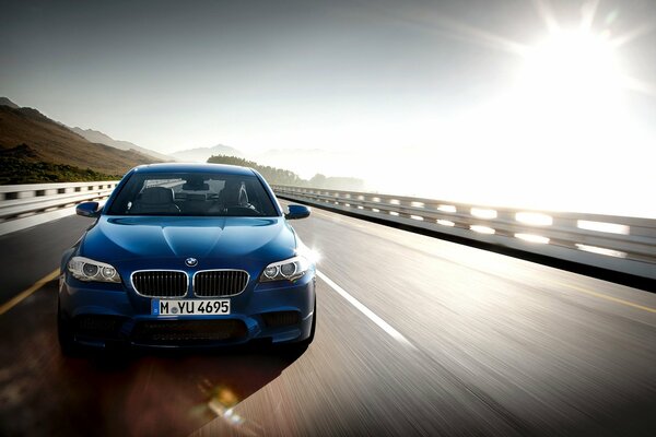 Bmw m5 flies on a sun-drenched highway