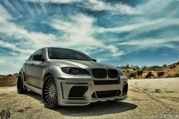 Grey beautiful BMW on the road against a cloudy blue sky