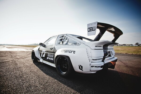 Voiture Toyota Levin blanc et noir sur la route près du champ