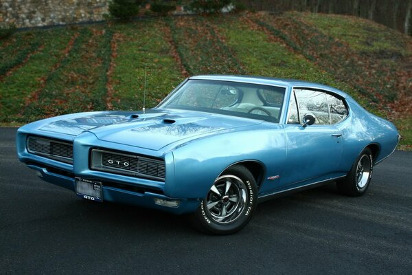 Blue unusual car on a lawn background 