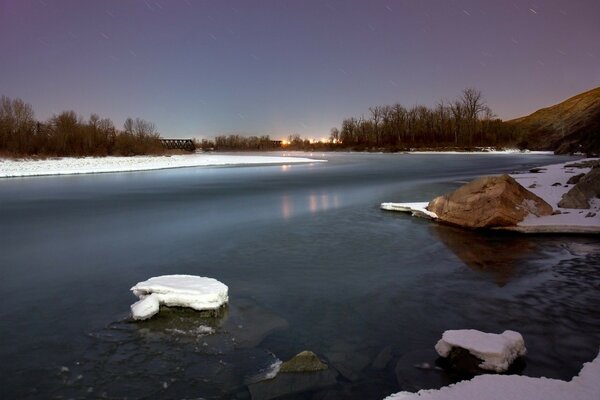 Зима на реке со снегом и камнями