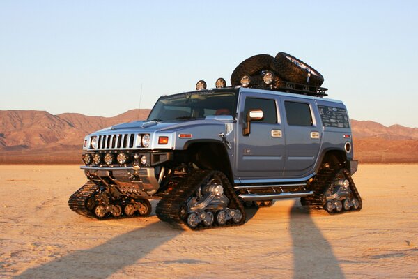 Мощный автомобиль Хаммер в пустыне на гусеницах вместо колес