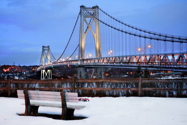 Winter in New York City, eine Datumsbank mit Blick auf die Brücke