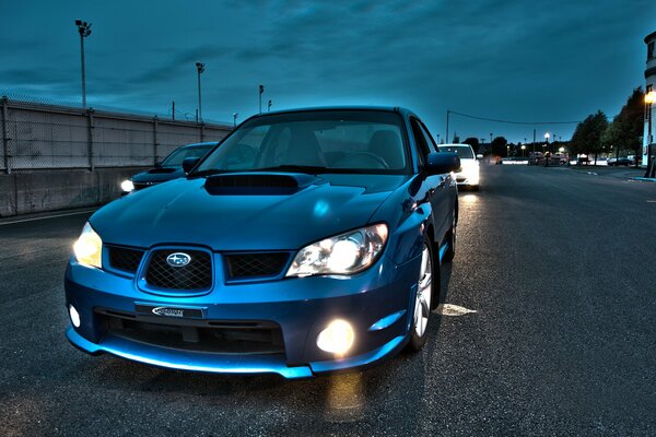 Blaues Auto Subaru am Abend auf der Straße