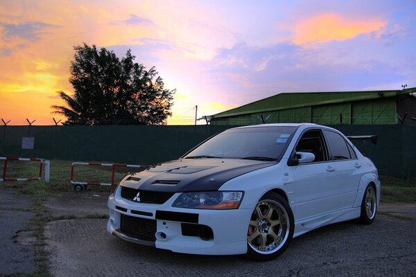 Mitsubishi afinado blanco en los rayos del atardecer