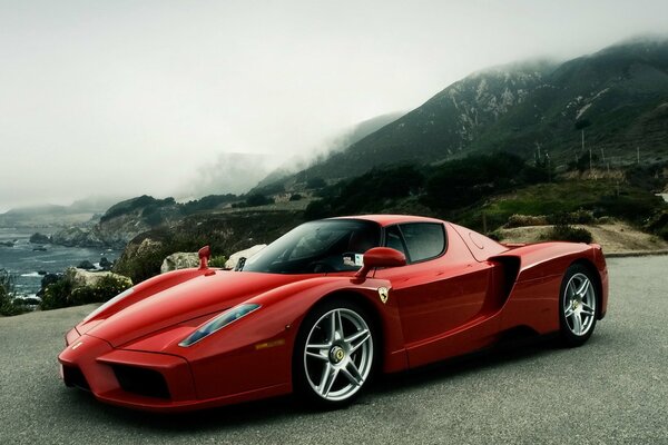 Ferrari sportive rouge sur fond de montagnes