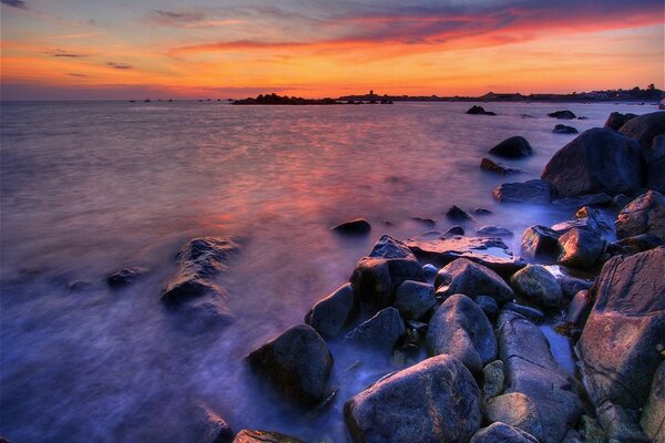 Blue stones and the sea at sunset