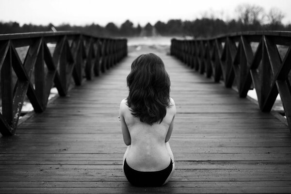 Fille solitaire sur un pont en bois