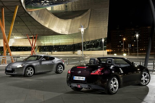 Two cars on the background of an unusual building