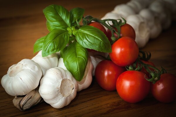 Garlic with tomatoes and herbs on the table