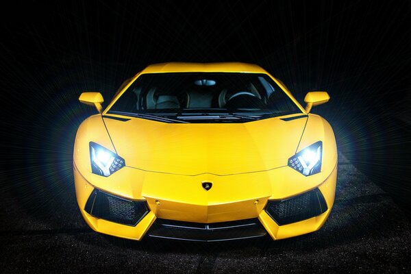 Żółty Lamborghini świeci reflektorami w nocy