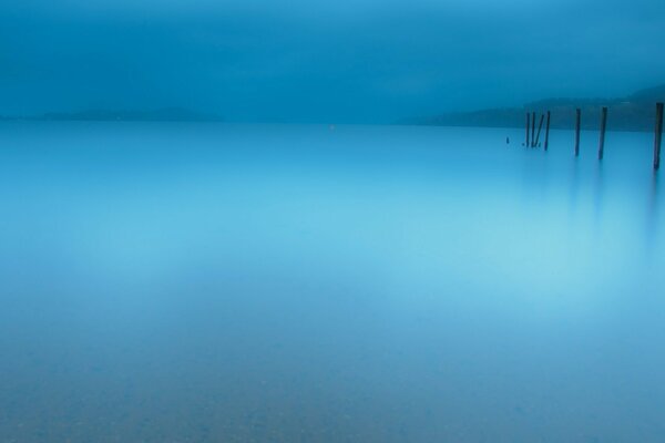 The fog over the lake is all in blue tones