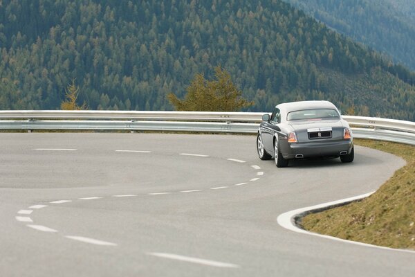 Rolls Royce su una curva stretta tra le montagne verdi