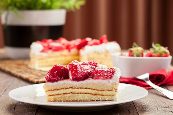 Pastel con crema de bayas y una rodaja de fresas