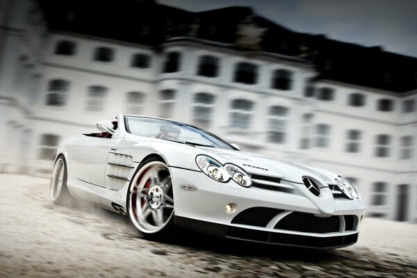 Marque de voiture Mercedes sport blanc en mouvement sur le fond d un immeuble de trois étages