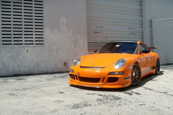 Porsche naranja en las afueras de la ciudad