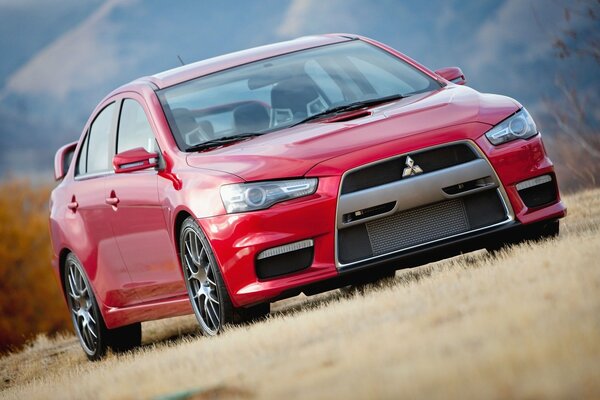 Prototipo rosso Mitsubishi sull erba lungo la strada