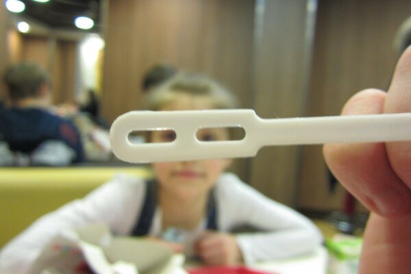 A child at McDonald s looks through a coffee spoon