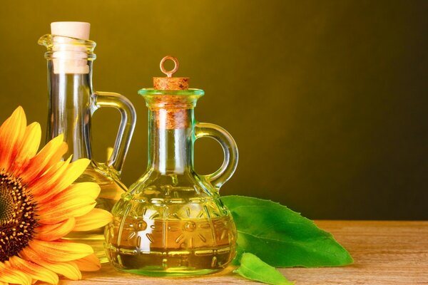 Bottiglia di vetro con olio di girasole in piedi su un tavolo di legno
