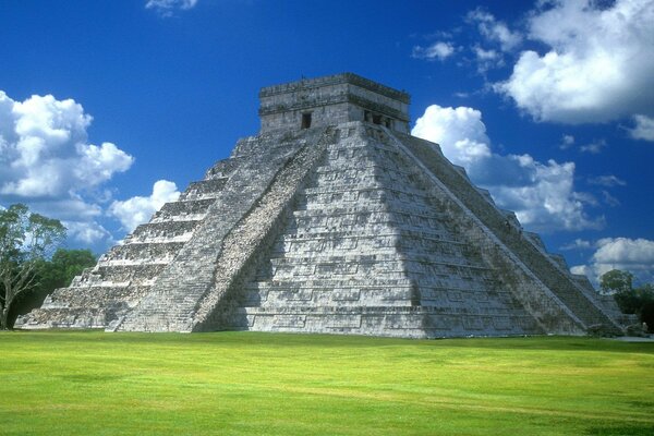 The pyramid of Kukulkan in Mexico on the green grass
