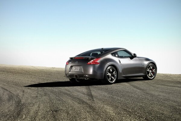 Nissan 370Z est debout sur la route sur fond de ciel