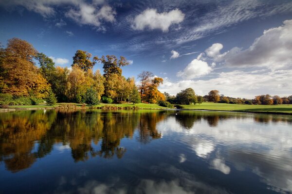 En otoño, el río se refleja en el cielo azul