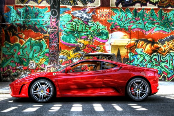 Czerwone auto na tle ściany z graffiti