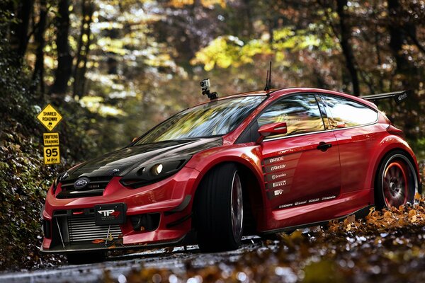 Coche Ford Focus rojo en el fondo de otoño de oro