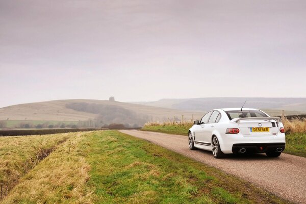 A white car with a spoiler in the field