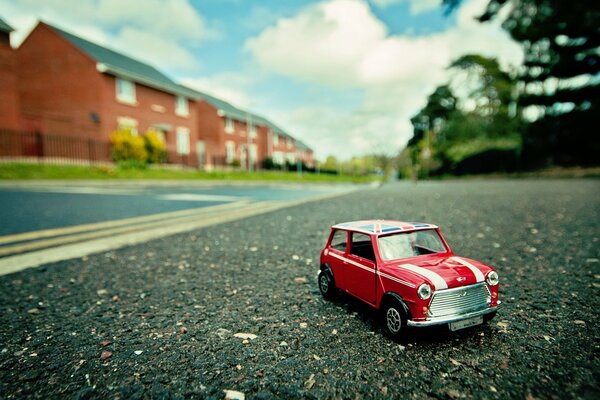 Macro photo of a red toy car mini on the asphalt