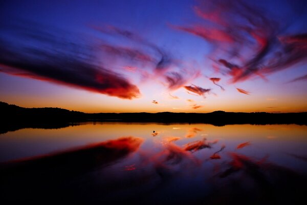 Purple clouds are reflected in the water