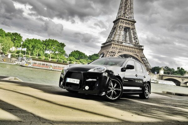 Un poderoso auto cerca de la poderosa torre Eiffel