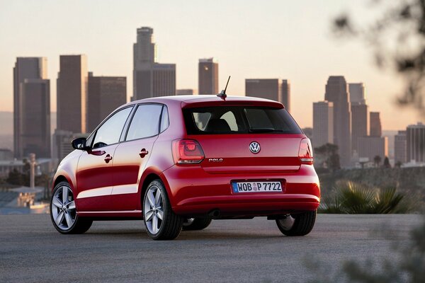 Un coche rojo circula por las carreteras de la ciudad