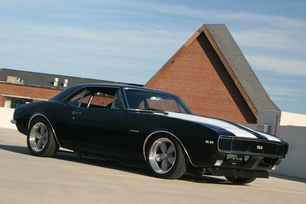 Retro chevrolet camaro with white stripes on the hood