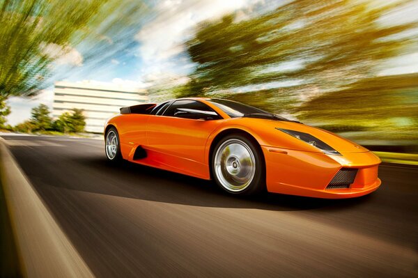 Ein leuchtend orange Lamborghini rast über die Straße