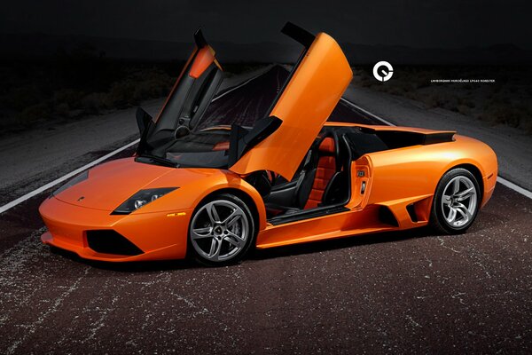 Arancione Lamborghini Murcielago si trova lungo il centro di una strada asfaltata