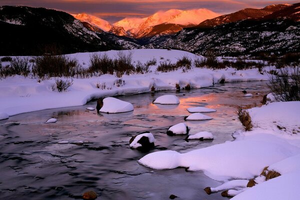 Verschneiter Gebirgsfluss im Winter