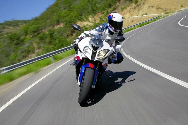 A motorcyclist rushes along a winding highway