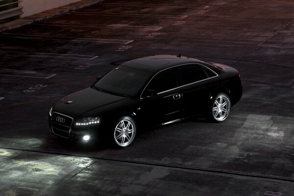 Audi negro en el estacionamiento nocturno