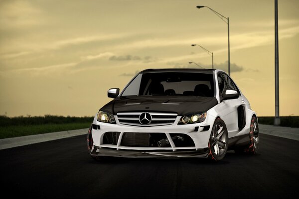 Un Mercedes blanco y negro en la carretera